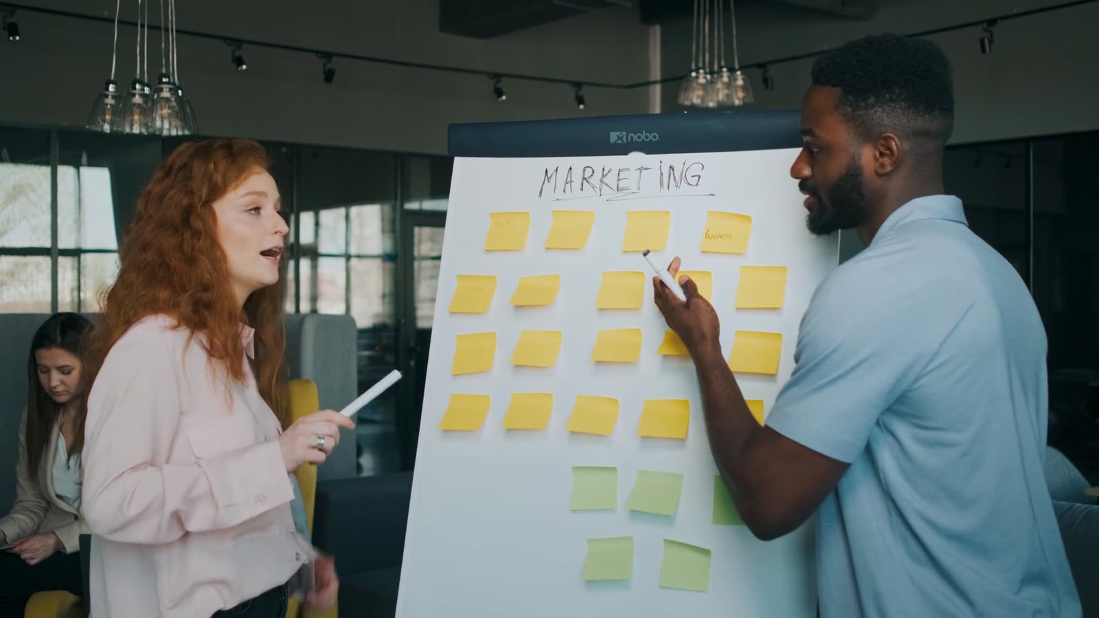 Dupla organizando post-its de marketing num quadro durante um diagnóstico